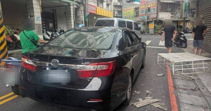 新北中和一民宅鐵窗施工發生意外，45歲王姓工人從4樓墜落，掉落的鐵窗砸中轎車。（圖／翻攝畫面）圖片